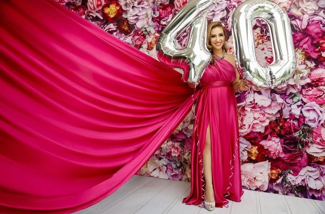 Flying dress — fuchsia gown, floral backdrop, balloons