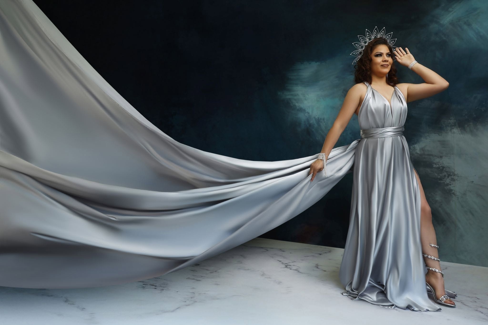 Flying dress — silver gown, teal backdrop, crown