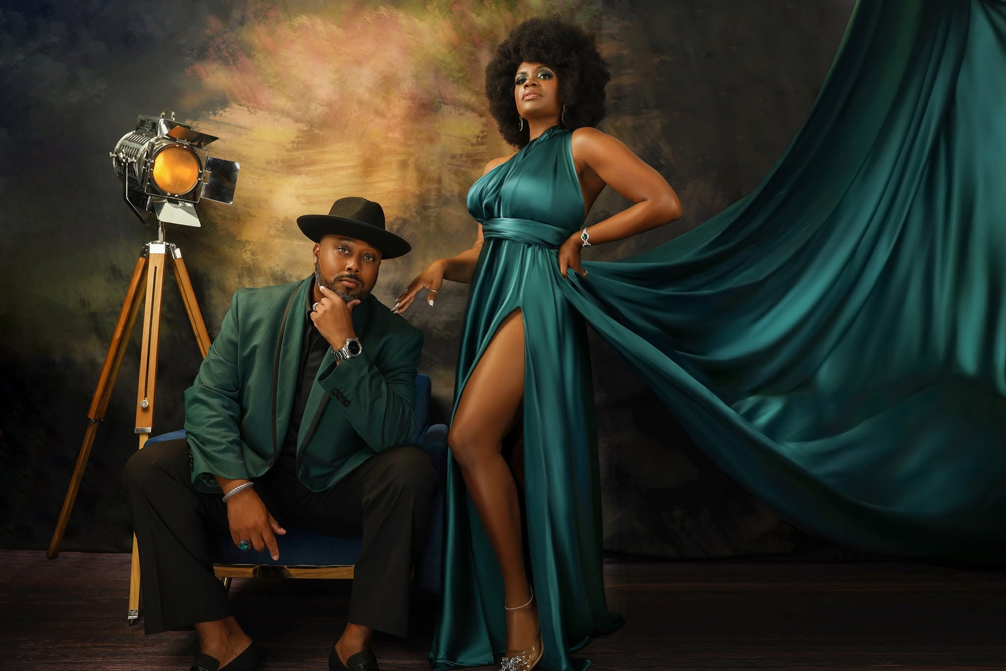 The Suttons — emerald green gown and suit, painterly studio backdrop